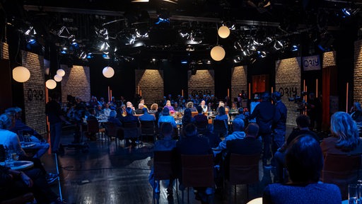 Gäste und das Moderatoren-Duo sitzen im 3nach9-Studio  um einen runden Tisch.