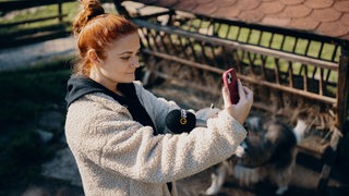 Reporterin mit Mikrofon und Smartphone