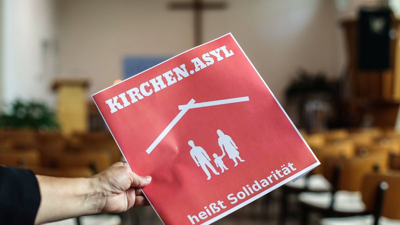 Schild mit der Aufschrift "Kirchenasyl heißt Solidarität" in einer evangelischen Kirche (Symbolbild)